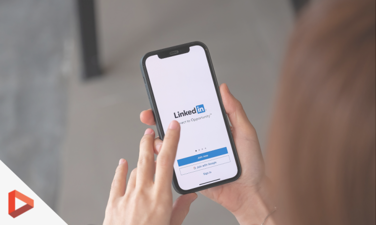 Mains tenant un smartphone affichant LinkedIn