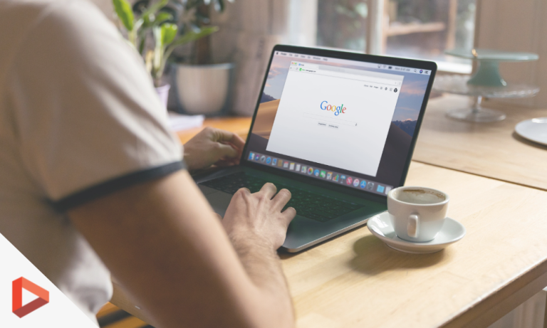Personne consultant Google sur un ordinateur portable avec un café