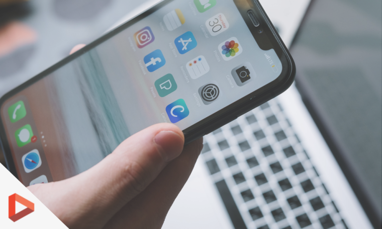 Main tenant un smartphone affichant des applications sociales