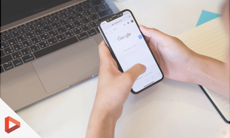 Main tenant un smartphone affichant Google
