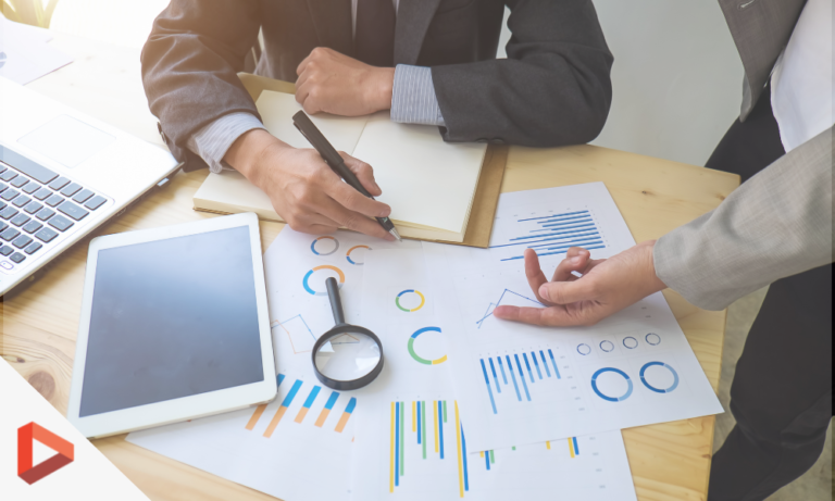 Équipe analysant des graphiques marketing autour d'un ordinateur portable