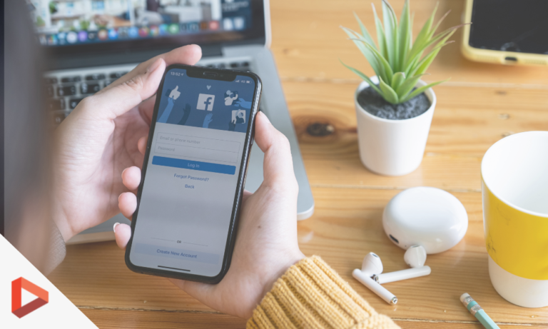 Main tenant un smartphone affichant une application, sur un bureau