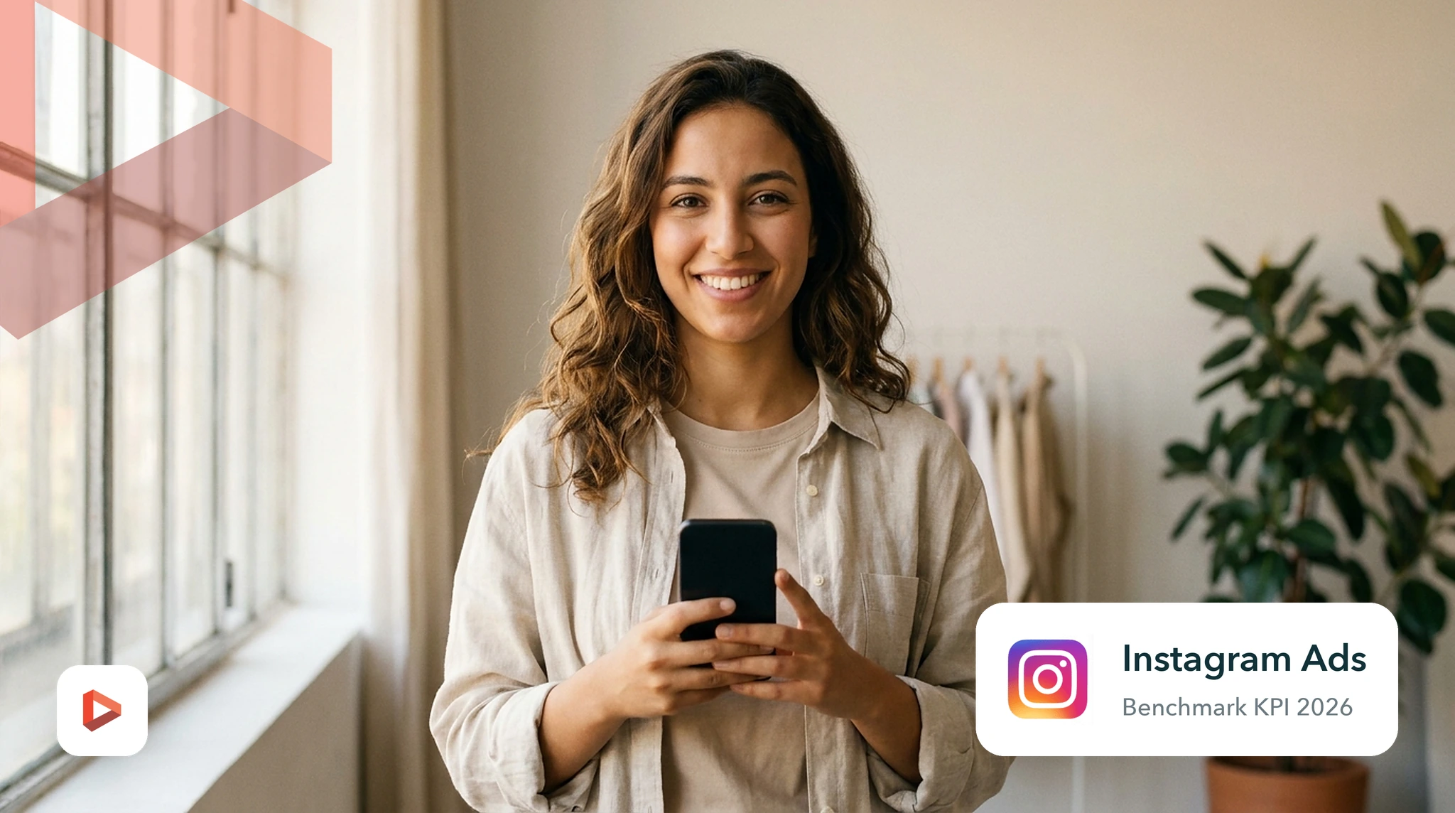 Créatrice de contenu tenant son smartphone dans un studio lumineux, benchmark KPI Instagram Ads 2026