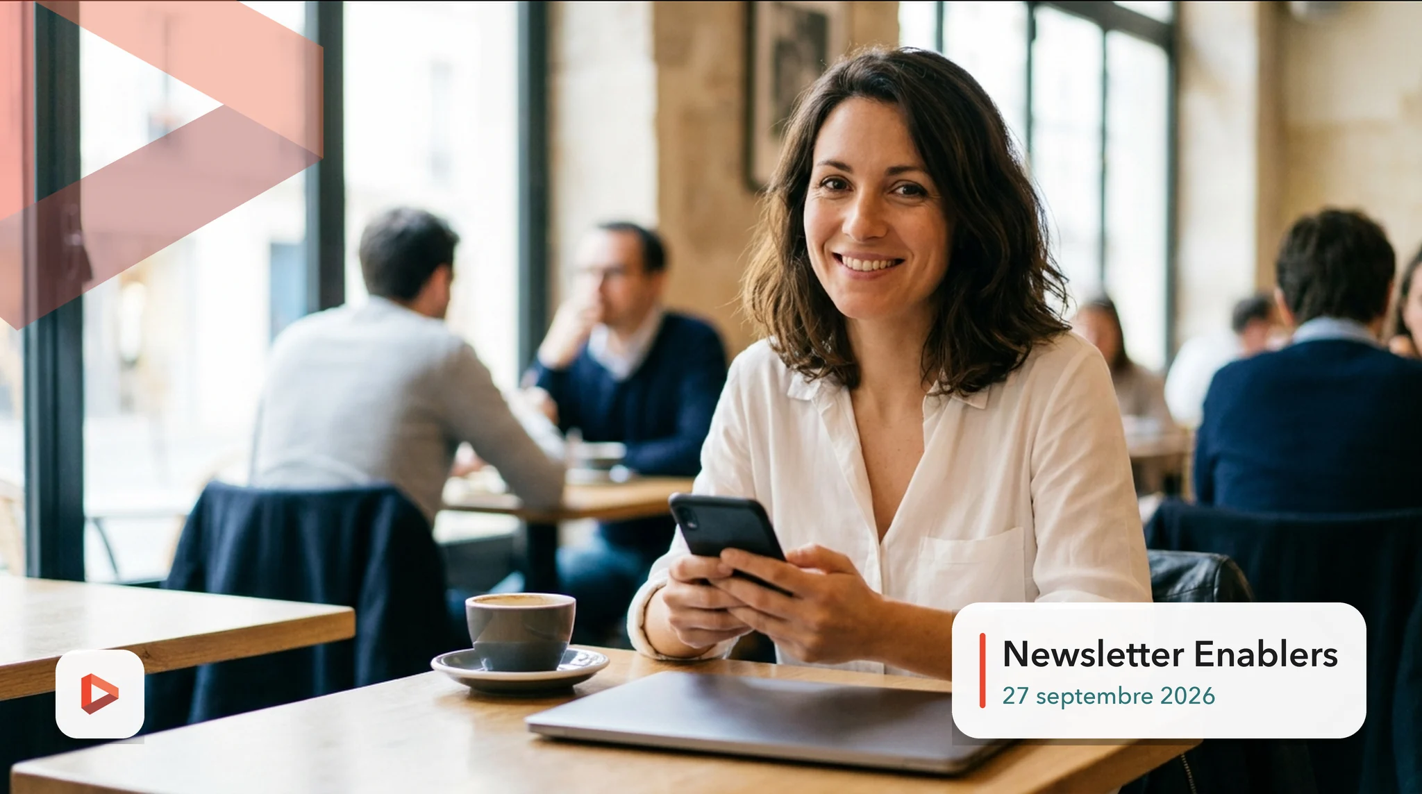 Responsable marketing souriante, smartphone en main dans un café, qui lit l'actualité digitale, newsletter Enablers du 27 septembre 2026